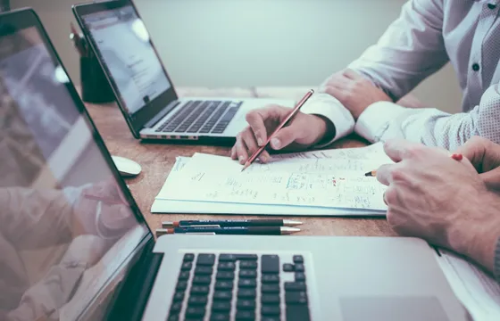 Ondernemer aan bureau met documenten en laptop