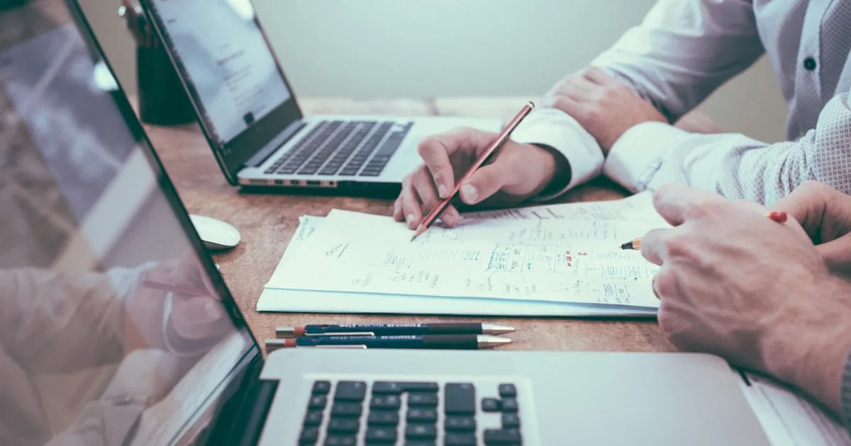 Ondernemer aan bureau met documenten en laptop