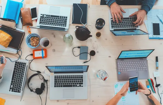 Mensen die samen aan tafel met laptops werken