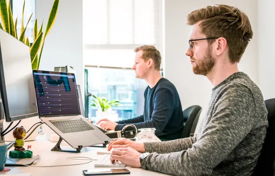 Ontwikkelaars of consultants die samen naar code op schermen kijken