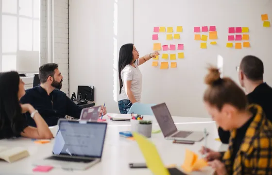 Team dat samen naar een whiteboard met werkprocessen kijkt