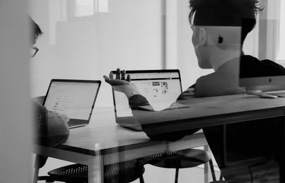 Collega's in overleg aan een tafel met laptops